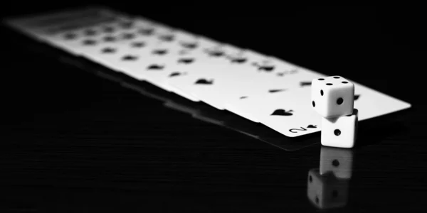 Gaming dice and a row of playing cards.