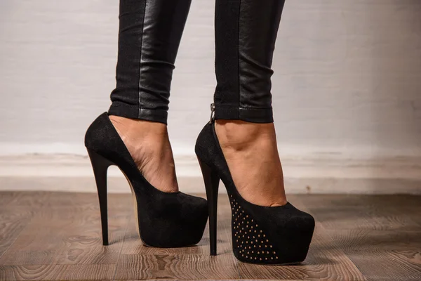 Slim female legs in dark  high heels