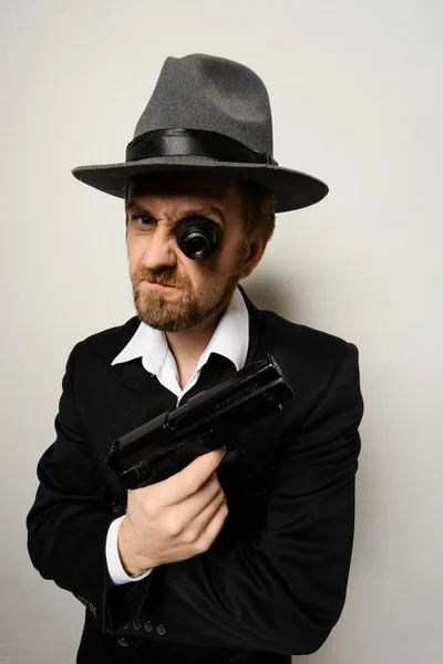 Crazy beard detective whit gun in hat