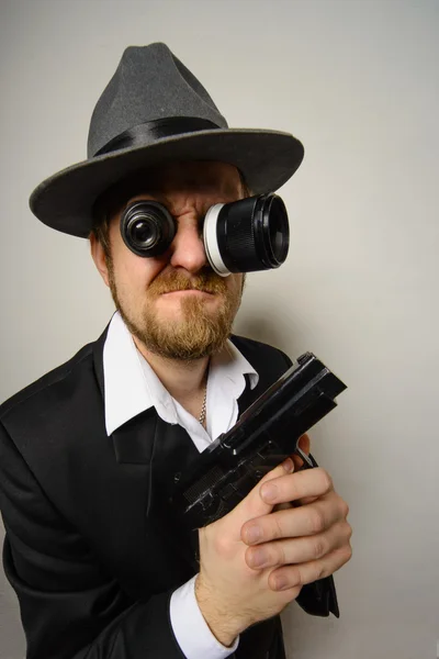 Crazy beard detective whit gun in hat