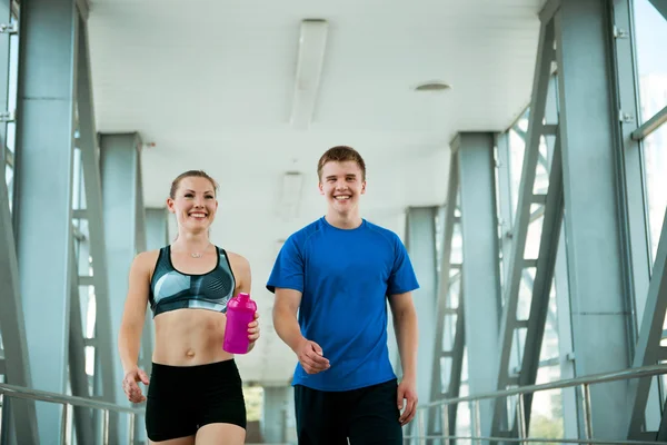 Sport fitness couple walking in modern interior after training