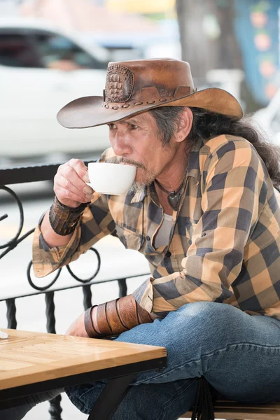 Asian cowboy with a Cup of coffee