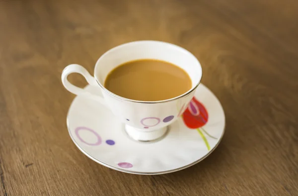 A  cup of coffee  in a white cup on wooden background