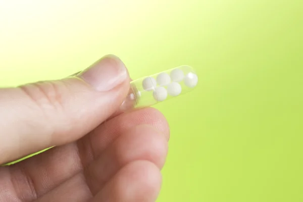 Homeopathy pill in hand