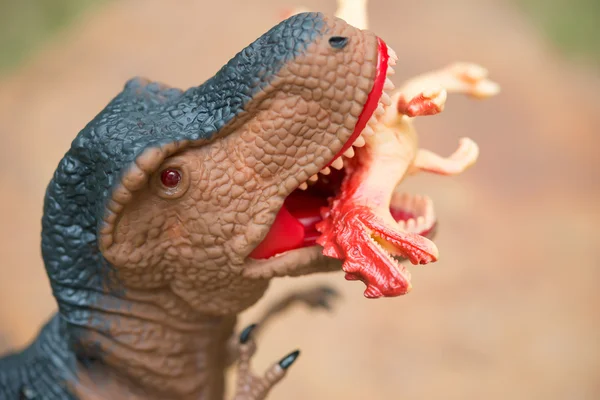 Gigantic tyrannosaurus bites a smaller dinosaur close up