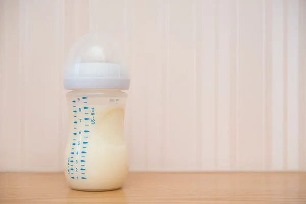 Baby bottle of powdered milk at home with copy space