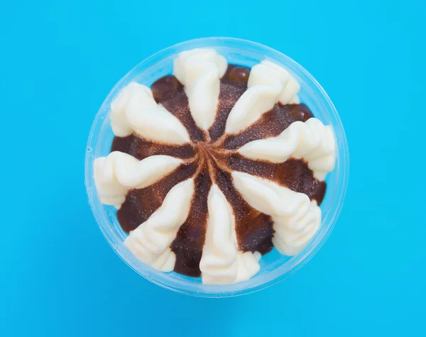 Top view cup of chocolate flavor ice cream on blue background close up