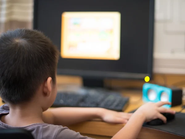 Kid playing a computer game for children at home