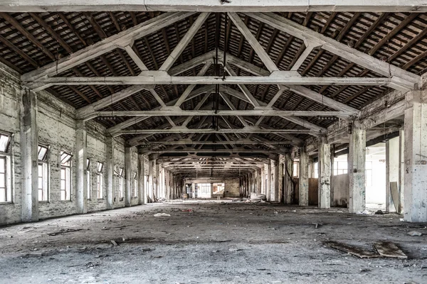 Empty industrial loft in an architectural background with bare cement walls, floors and pillars supporting a mezzanine