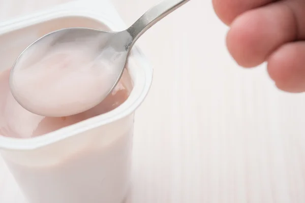 Eating strawberry flavor yogurt close up