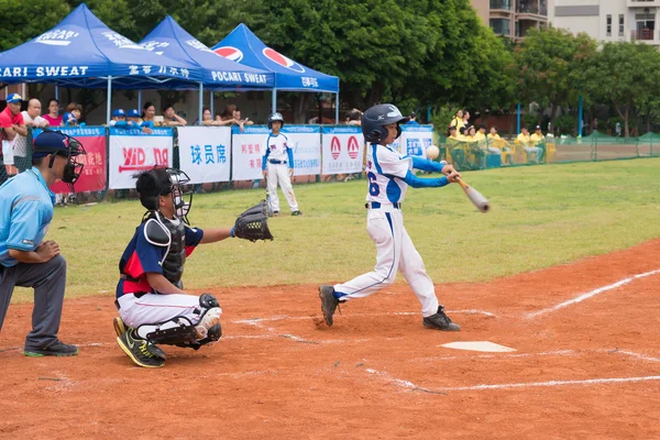 ZHONGSHAN PANDA CUP, ZHONGSHAN, GUANGDONG - July 23:batter of team Zhongshan TongMao Primary School hit the bal l and the ball slided away during a match of 2015 National Baseball Championship Group A of Panda Cup against WenZhou XinTianYuan Primary