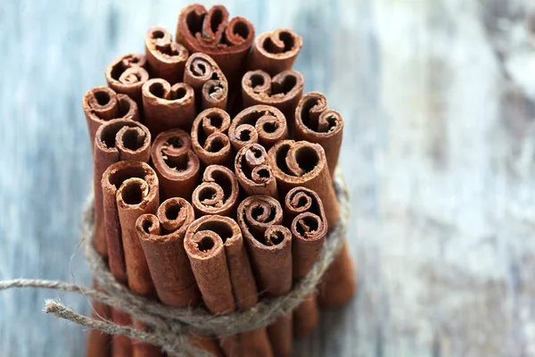 Bunch of cinnamon sticks on an old wooden table background, sele
