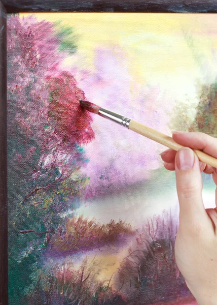 The artist paints a picture of the landscape using oily paints m