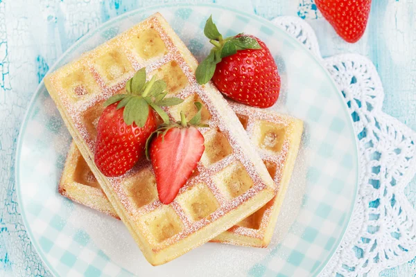 Homemade Belgium waffles with strawberries and powdered sugar on