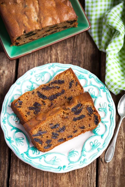 Cake with prunes and almond flour on a wooden table with a green