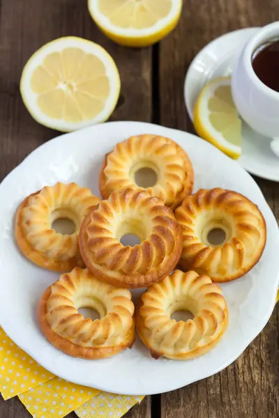 Homemade yellow lemon cakes on wooden table, selective focus