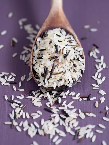 Raw rice on a wooden spoon