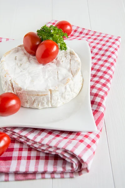 A round Camembert on a white plate
