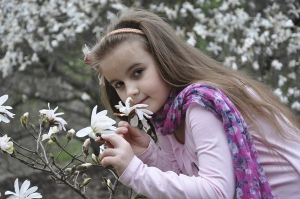 Spring girl smelling a magnolia.