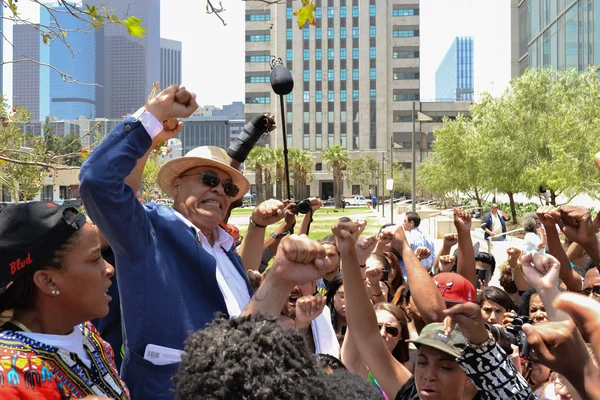 Black lives matter protestors put their fists in the air as a si