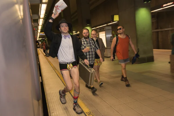 A man without pants running in the metro station during the 