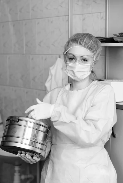 Monochrome portrait of a nurse holding a box for sterilization of medical instruments