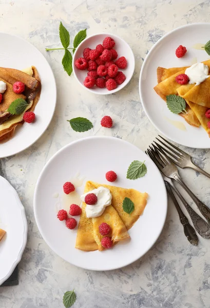 Crepes with raspberry on plates