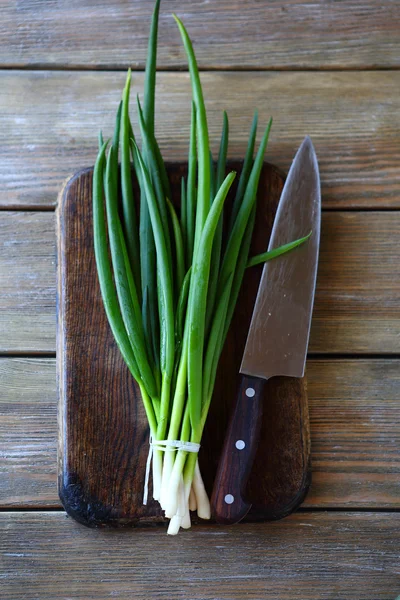 Green onion and knife on cutting board