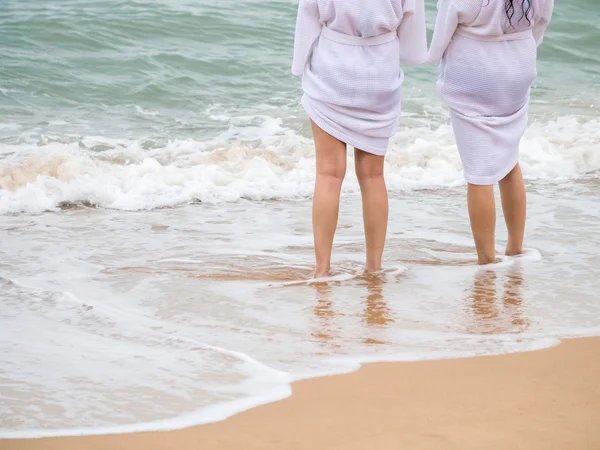 Women legs standing on the beach