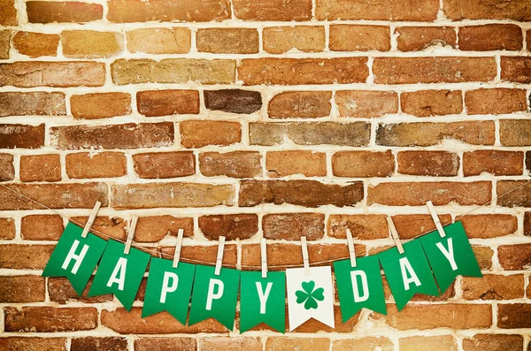 HAPPY ST. PATRICK\'S DAY banner lettering on red, old orange brick wall background. Irish national colors St. Patrick\'s Day greeting postcard template. Space for cope, text.