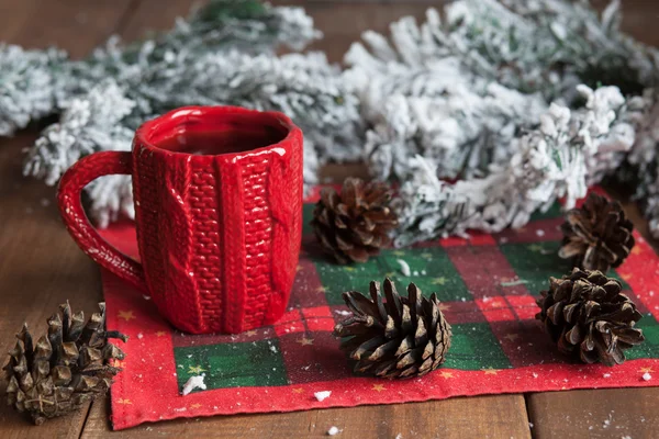 Cup of tea, fir cones, fir branches in the snow