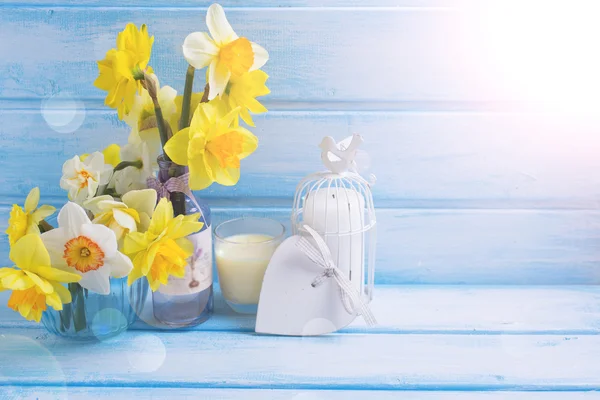 Narcissus in vases on wooden background