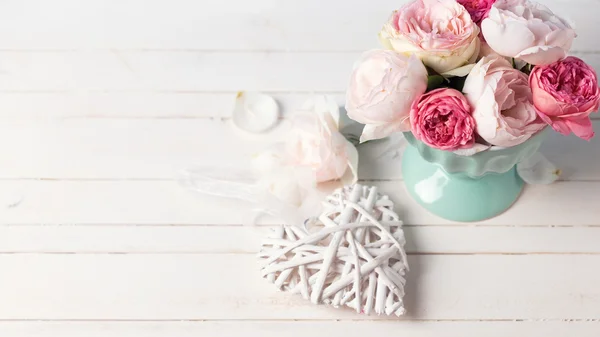 Pastel roses in vase  and decorative heart