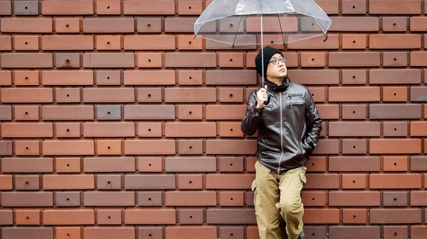 An Asian Man in a Brown Jacket With a Clear Umbrella
