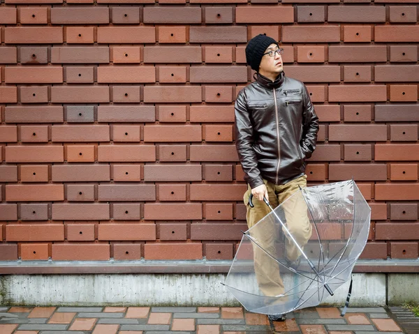 An Asian Man in a Brown Jacket With a Clear Umbrella