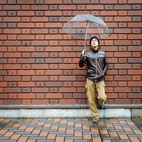 An Asian Man in a Brown Jacket With a Clear Umbrella