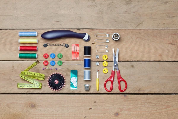 Set of tailoring tools on wooden background