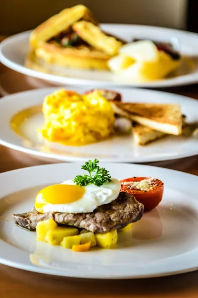 Sirloin steak topped with fried egg and breakfast potatoes, Soft scrambled eggs with smoked salmon.  Served with grilled tomato and wheat toast. Waffle, served with cinnamon poached pears