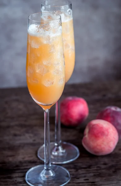 Two bellini cocktails with fresh peaches