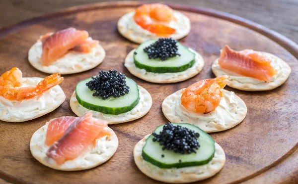 Canape with seafood on the wooden board