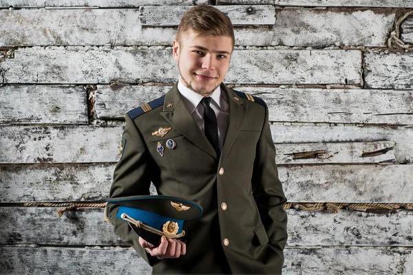 Young Russian Air Force sergeant posing holding his cap in his hands