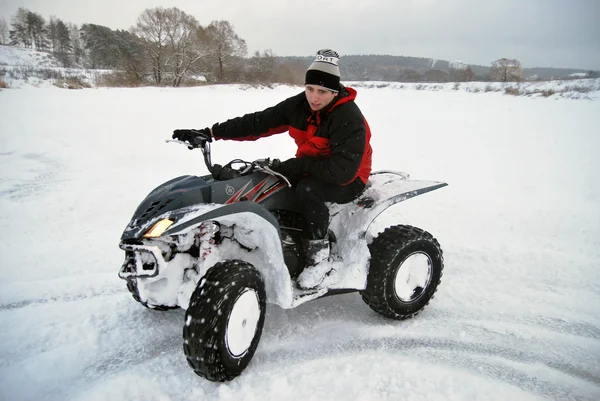 The young man at the time of extreme quad biking in the winter