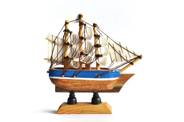 Wooden model ship with sails on a white background