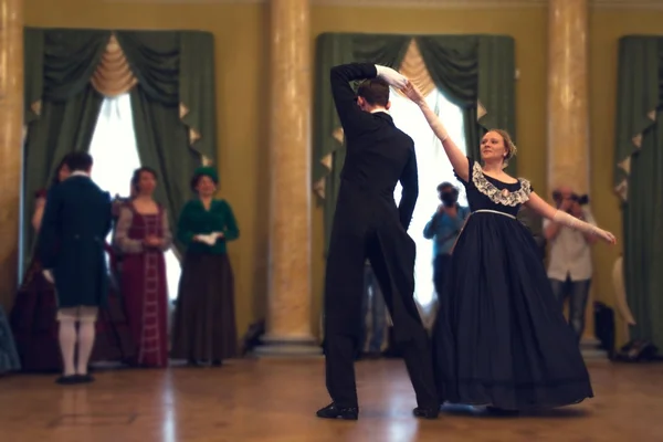 Pair in historical dress dancing a waltz in the ballroom