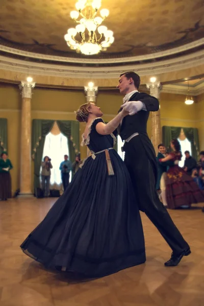 Pair in historical dress dancing a waltz in the ballroom