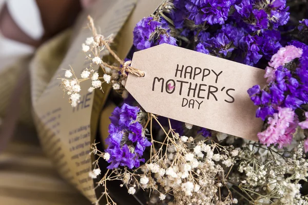 Bouquet of dried flowers with mothers day card on the wooden tab