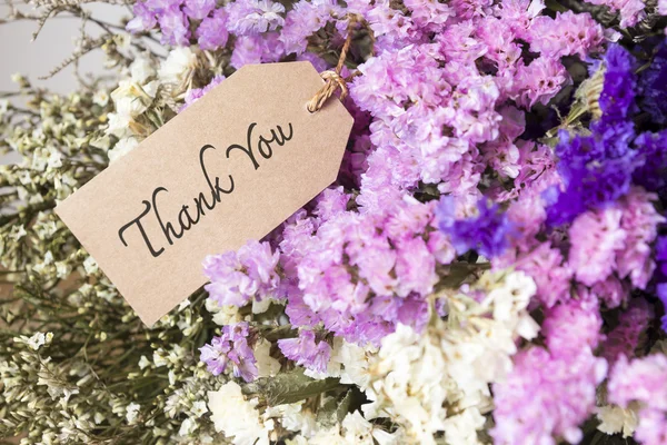 Bouquet of dried flowers with thank you card on the wooden table