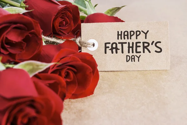 Red roses with fathers day card on brown paper