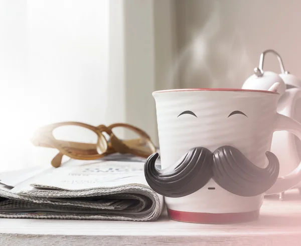 Cup with mustache on wooden table for fathers day concept