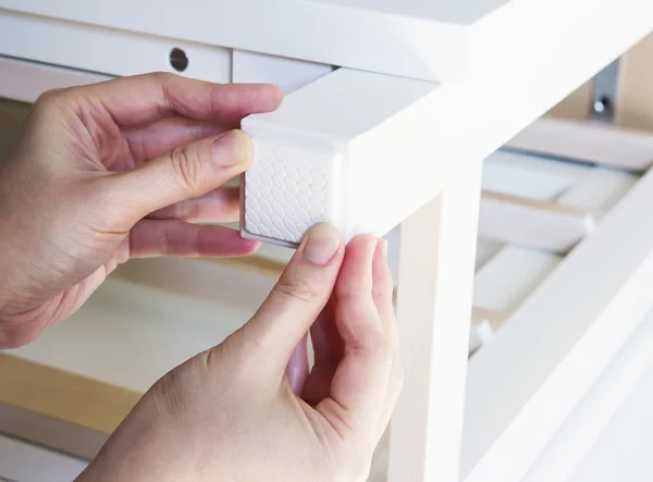 Young woman are sticking floor care pad at the table legs